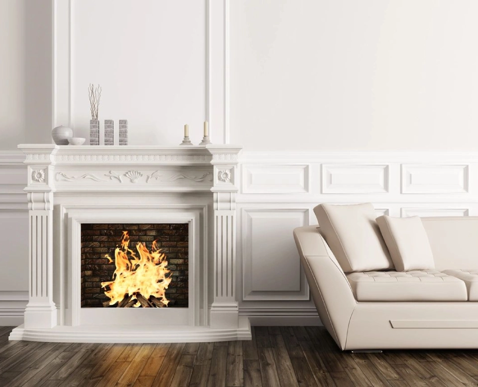 A fireplace in the corner of a room with white walls.