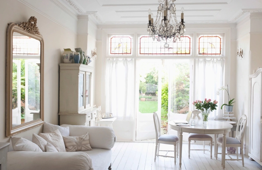 A living room with white furniture and a table