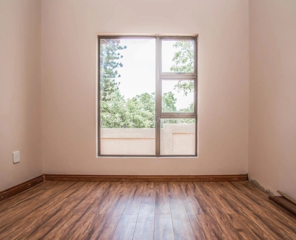 A room with a window and wooden floors