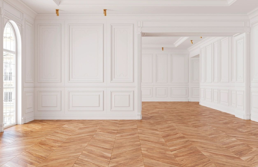 A large empty room with white walls and wooden floors.